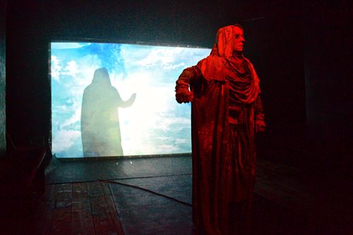 Personnage en costume rouge devant une projection